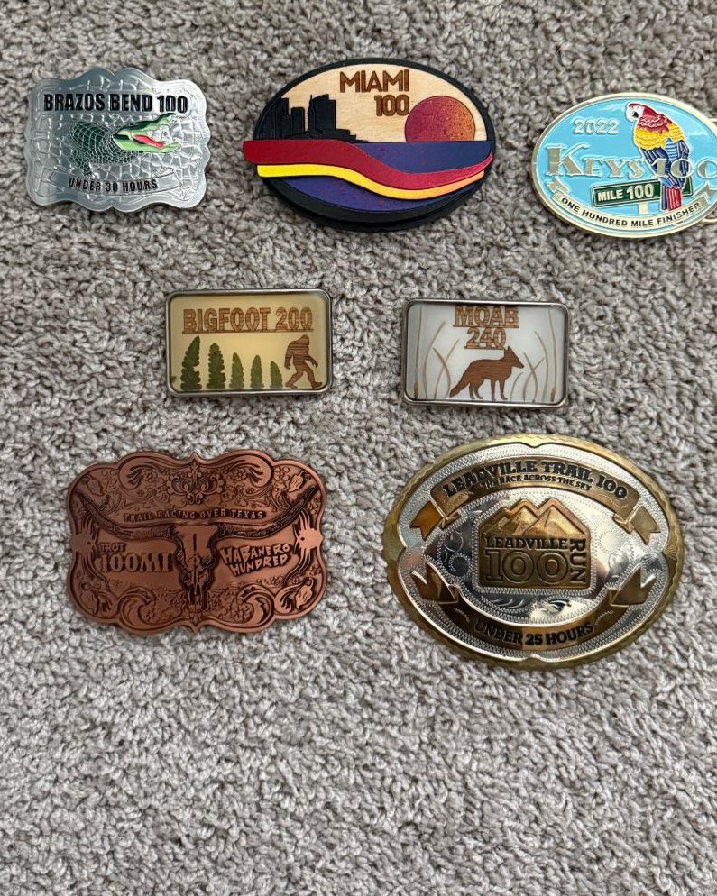 Pierce Showe's ultramarathon finisher belt buckles: Brazos Bend 100, Miami 100, Keys 100, Bigfoot 200, Moab 240, Habanero 100 and Leadville Trail 100
